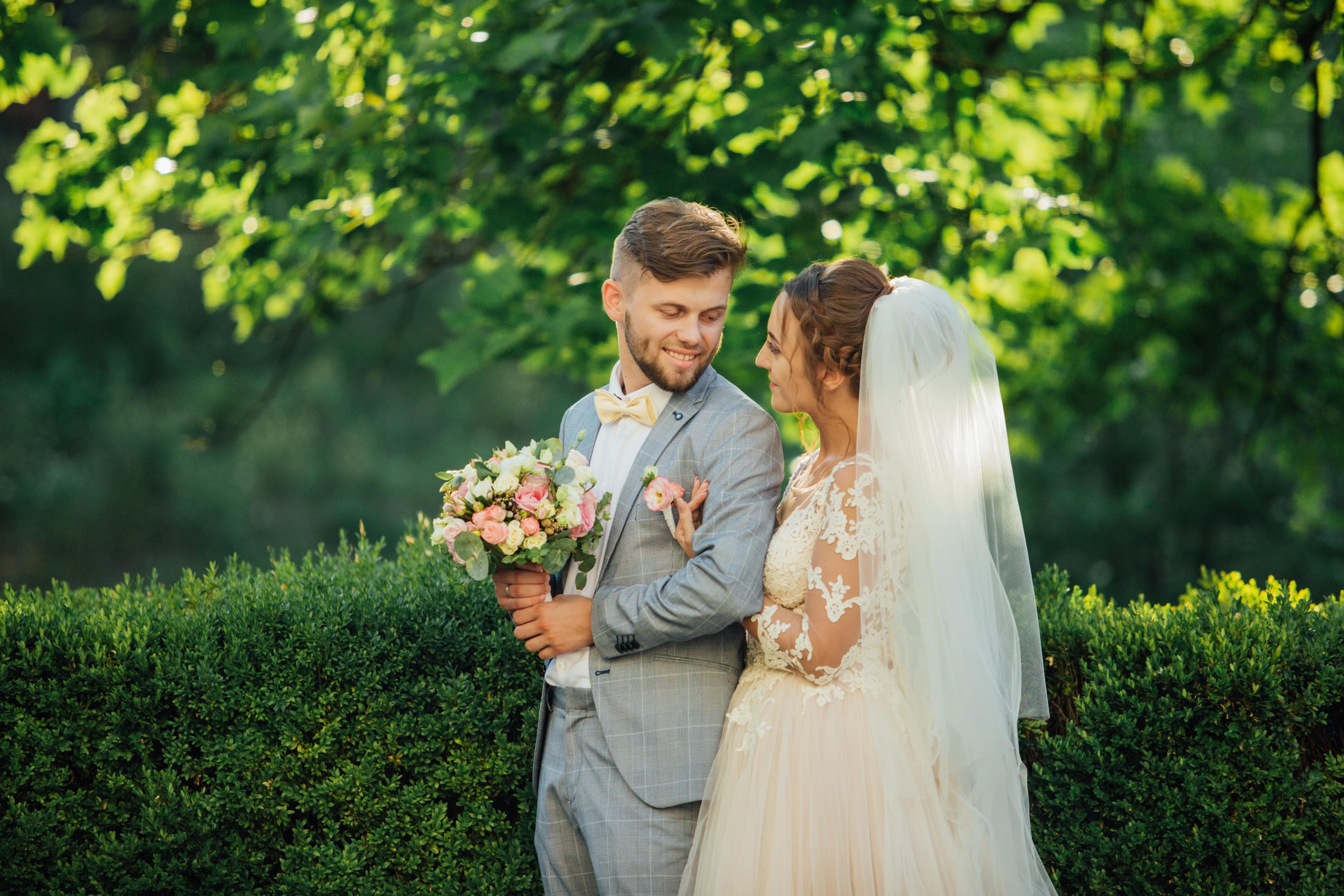Brudepar under trær i solskinn