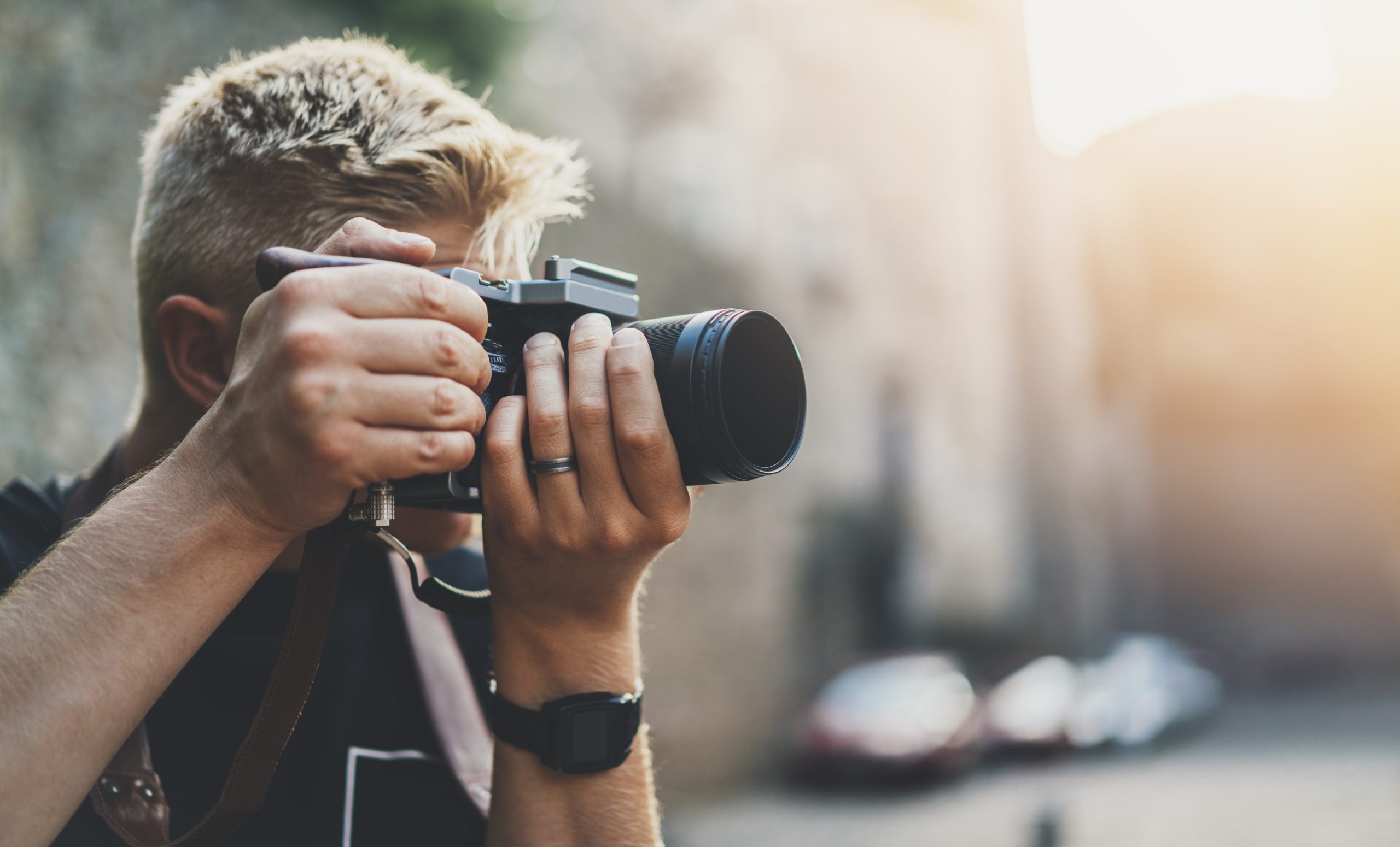 Mann fotograferer med kameraet sitt.