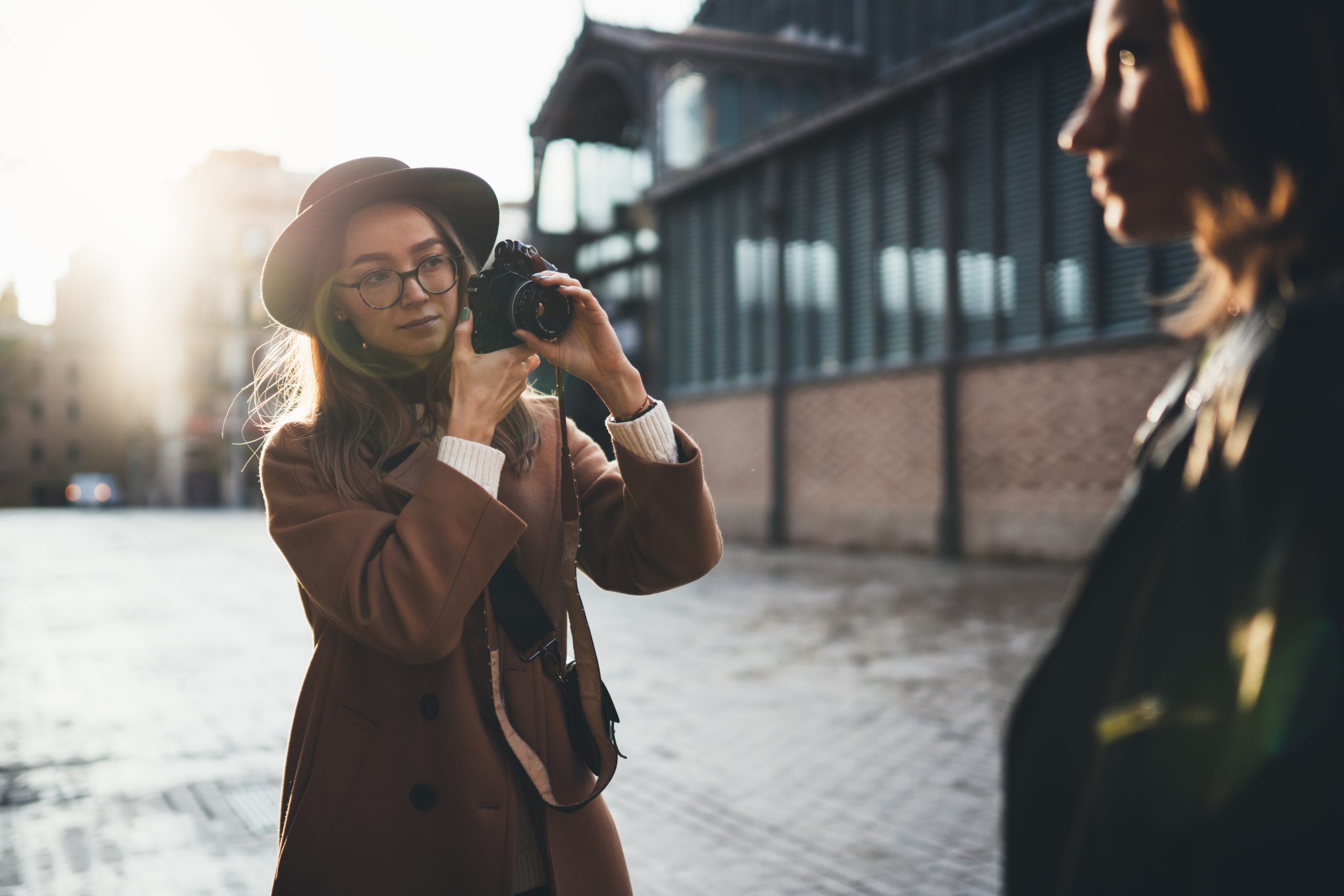 Kvinne fotograferer en annen kvinne i byen