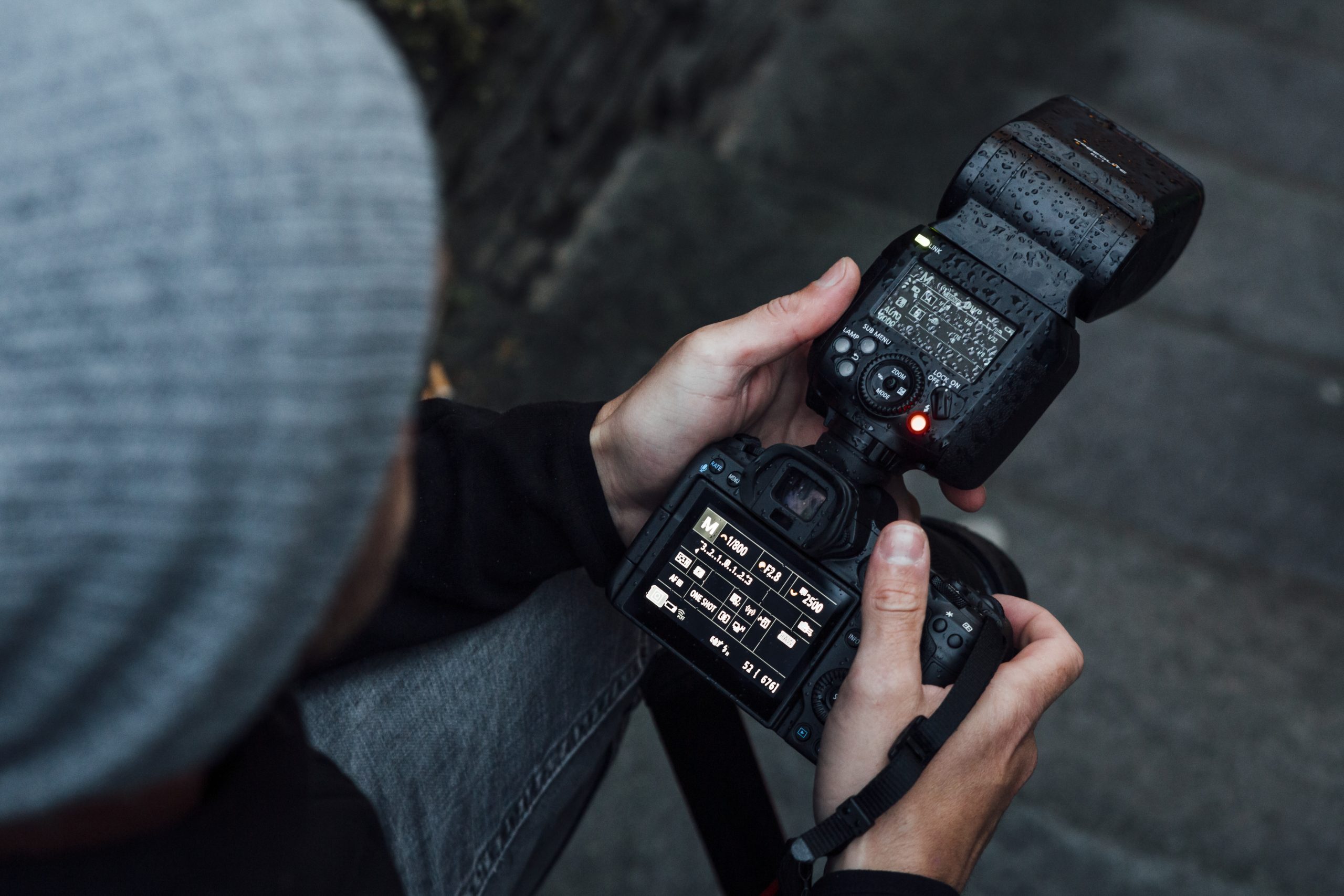 Mann holder kamera med Canon Speedlite EL-1 montert