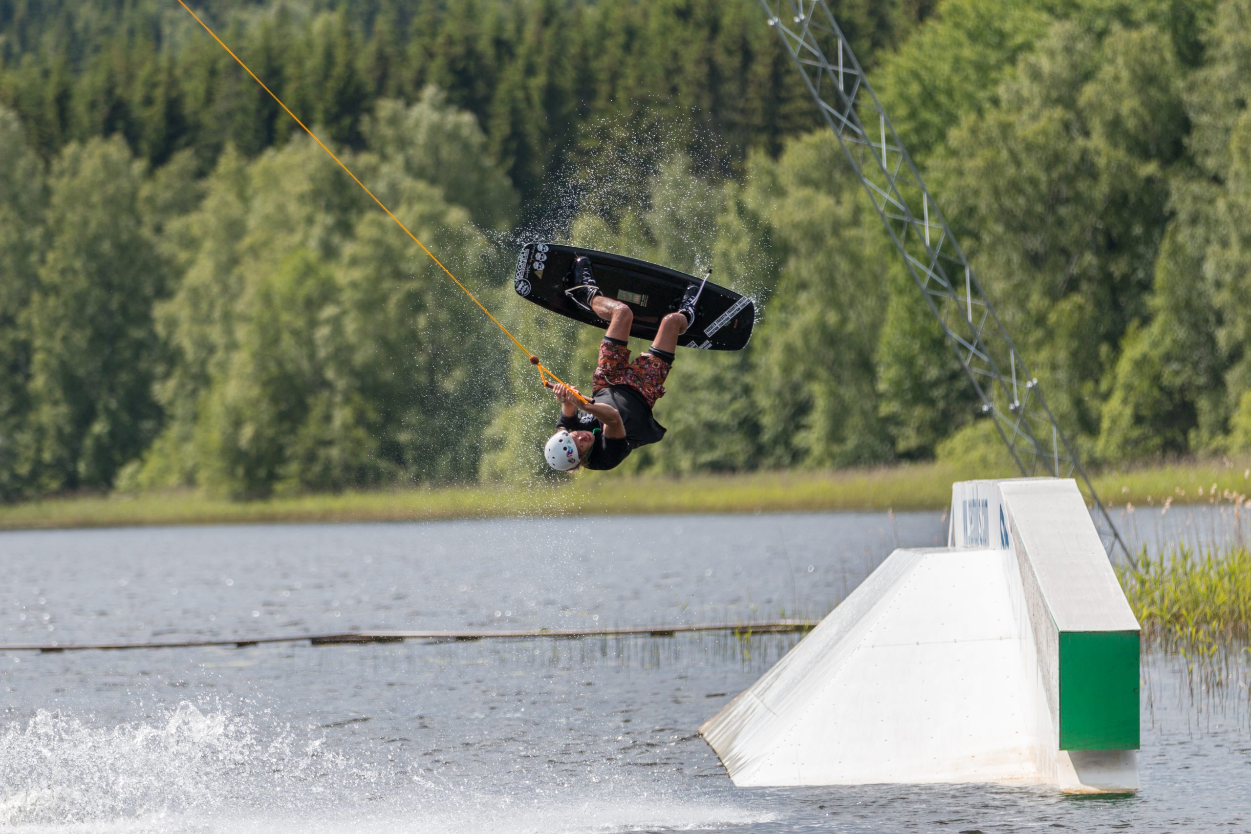 Mann på wakeboard blir dratt gjennom luften.