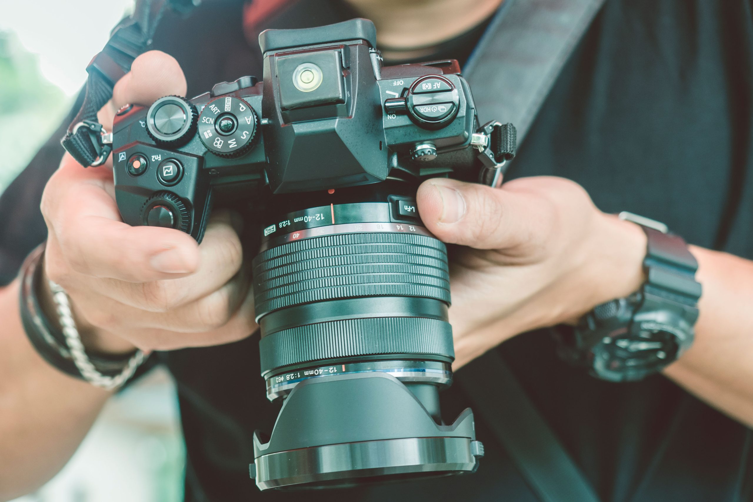 Järjestelmäkamera miehen käsissä.