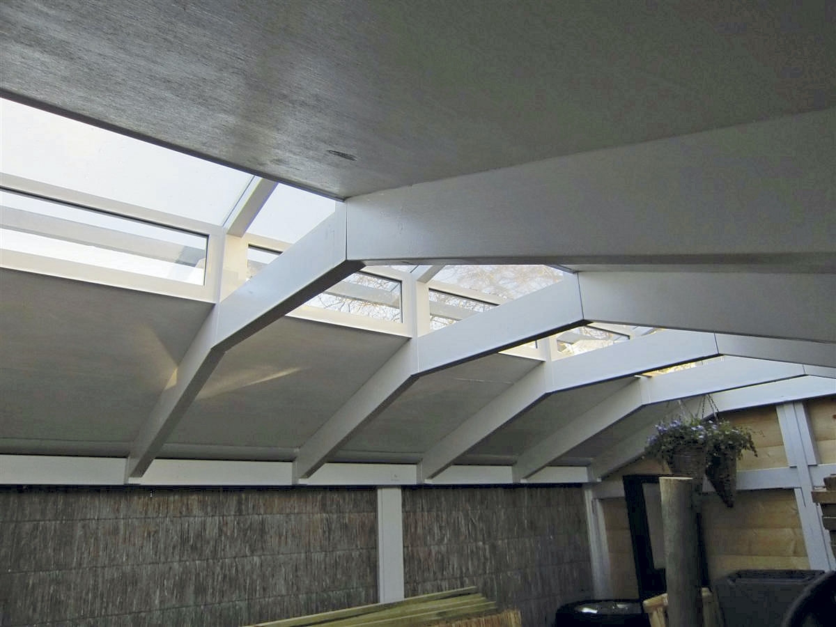 Der er bygget et træskelet af lægter, som løfter taget. Ved at sætte glas i siderne lukkes der ekstra meget lys ind i redskabsskuret.