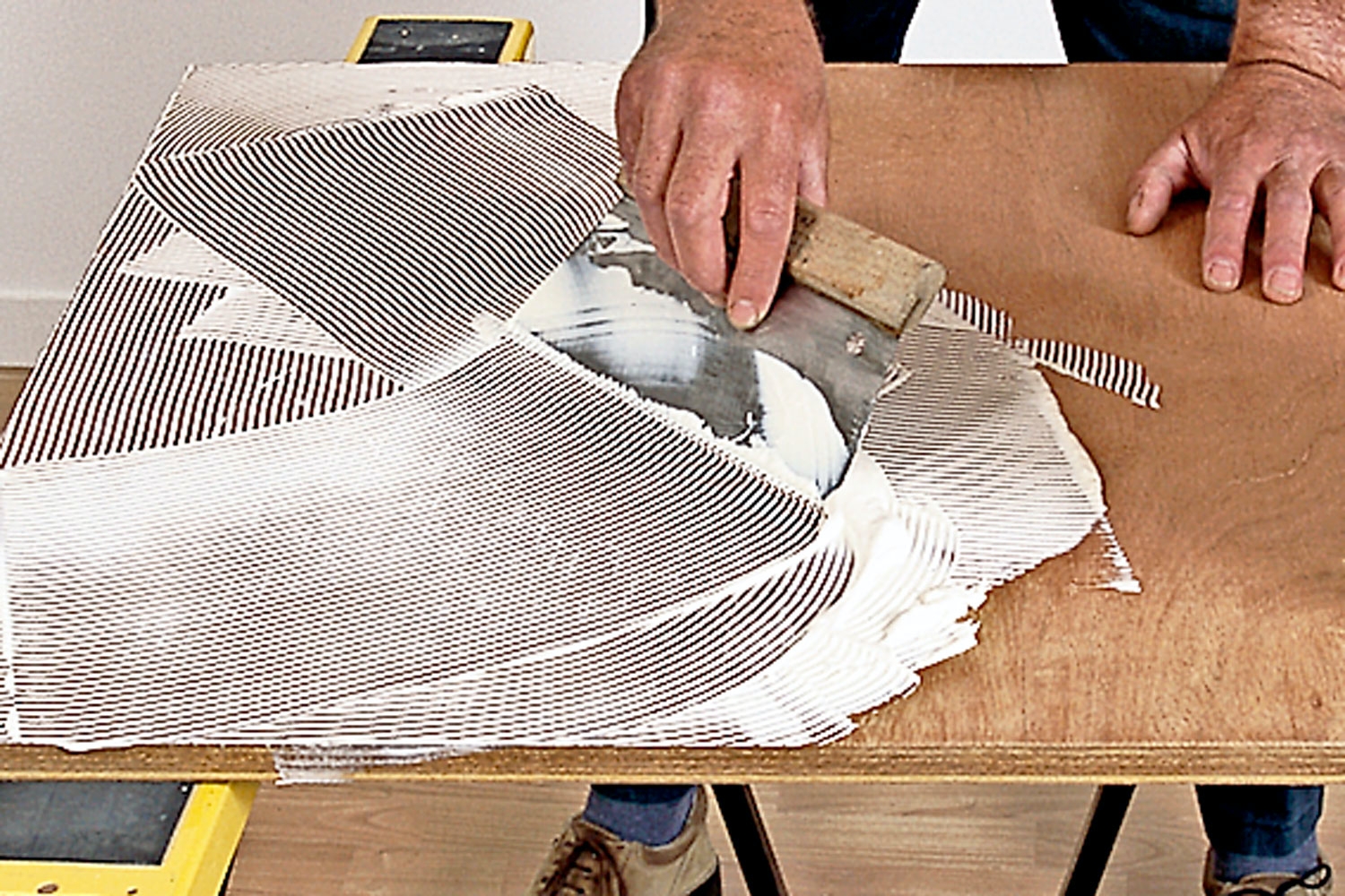 Linoleum: Liima levitetään alustalle lastalla tasaiseksi kerrokseksi.