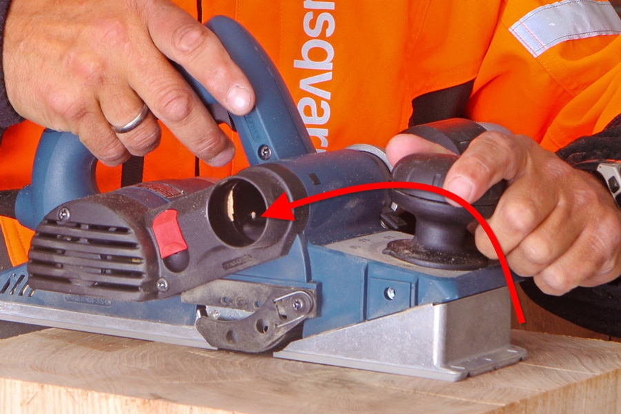 Lastuista syntyy vähemmän sotkua, kun sähköhöylä kiinnitetään pölynimuriin. Kuvassa näkyy, miten pölynimuri kiinnitetään höylään.