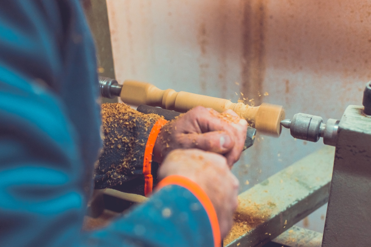 DREJEBÆNK: Her drejes der et ben. Maskinen drejer træet rundt, og drejejernet skærer det uuønskede træ væk. Det er sådan, drejebænken fungerer.