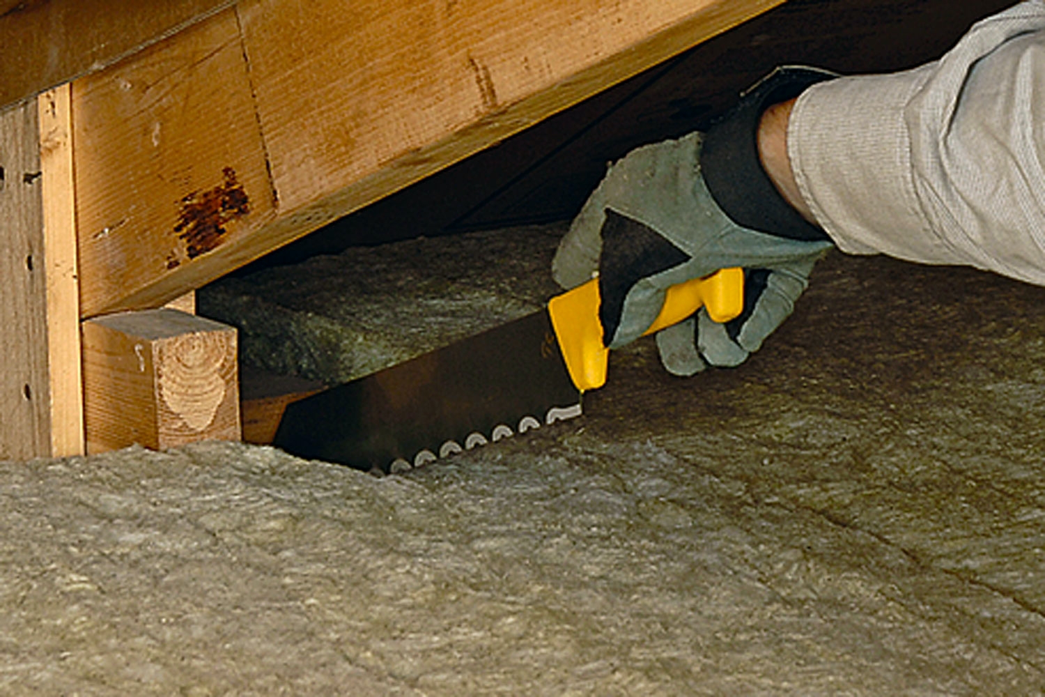 Mineralull skjæres til med en lang kniv