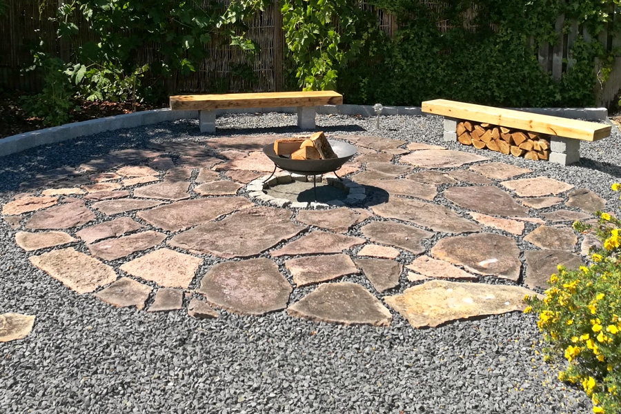 Terrass i natursten med eldstad