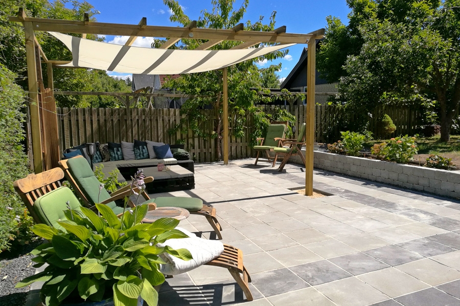 Myshörna med plattor: Snygg terrass med plattor, pergola och solsegel