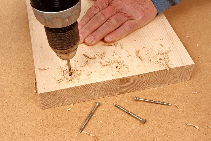Skarv med synliga pluggar: Förborra för skruvar i den ena träbiten