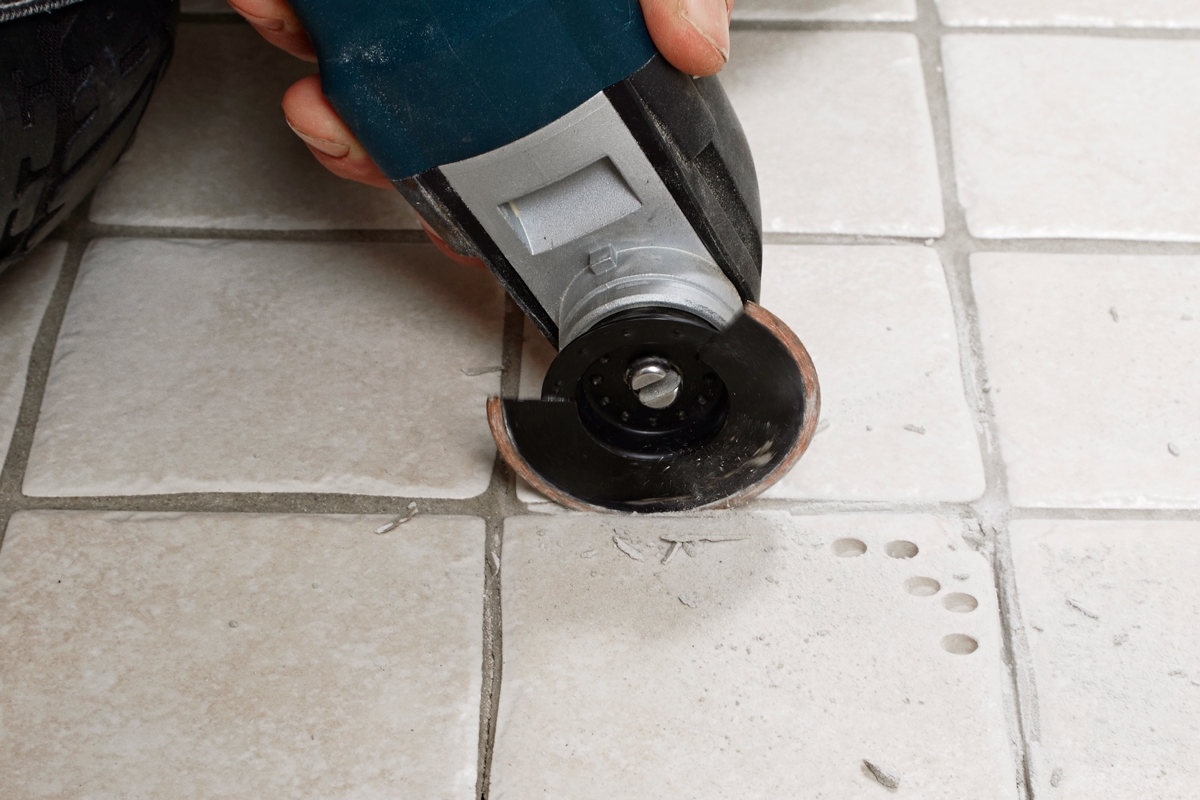 Fräs fogarna runt om en trasig platta med multiverktygen: Med en extra tunn klinga tas fogen kring plattan bort.