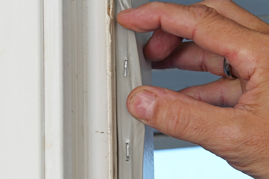 Montering av tätningslister med häftklammer: Listen sitter fast, och drar man i den yttre vingen och släpper, så kommer den att dra sig samman igen.
