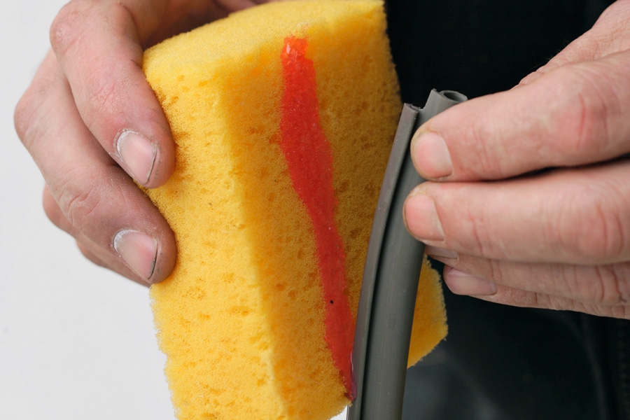 Montering i frästa spår: Den nya tätningslisten gnids med diskmedel, så att den lättare glider in i spåret.