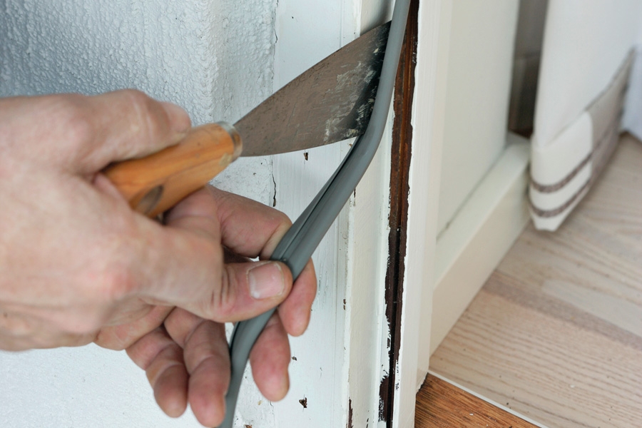 Montering i frästa spår: Tätningslisten trycks ner i spåret med en spackel.