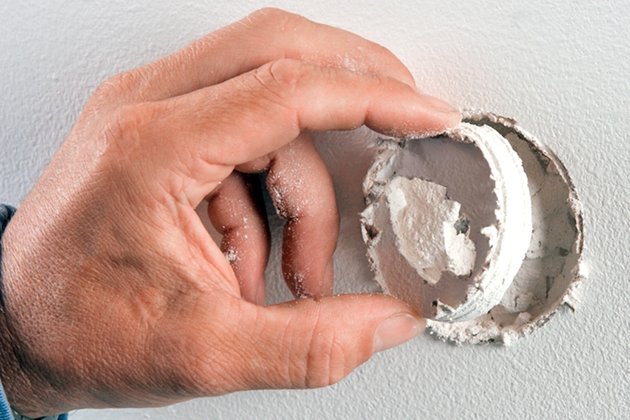 Tett hullet i vegger med to lag gips (små hull): Det ødelagte stykket bores ut med det lille koppboret, og gipsstykket fjernes.