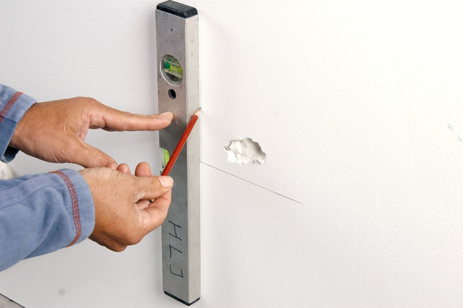 Tett hullet i vegger med to lag gips (store hull): Tegn opp en vinkelrett firkant rundt hullet, for eksempel med et vater.