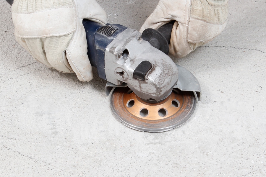 Sådan spartler du et plant betongulv: Slib toppene af med en vinkel- sliber med diamantslibekop.