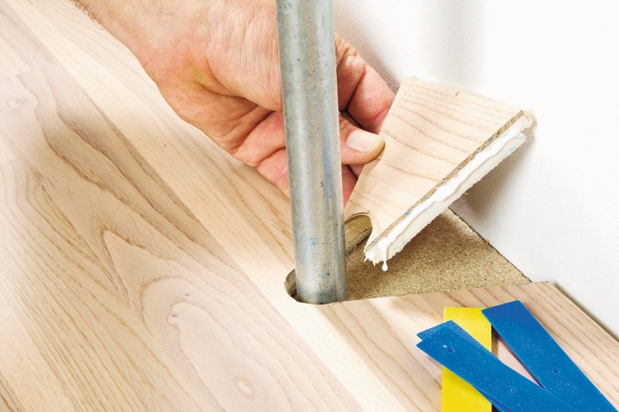 Et trægulv har helt tætte samlinger, og det gælder om at komme uden om rørene, så samlingerne her også bliver helt tætte.