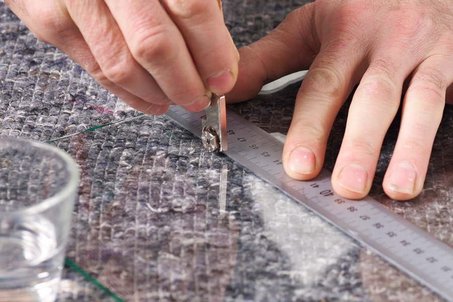 Skjær i glass: Glasskjæreren føres langs en metallinjal, mens du holder et konstant trykk.