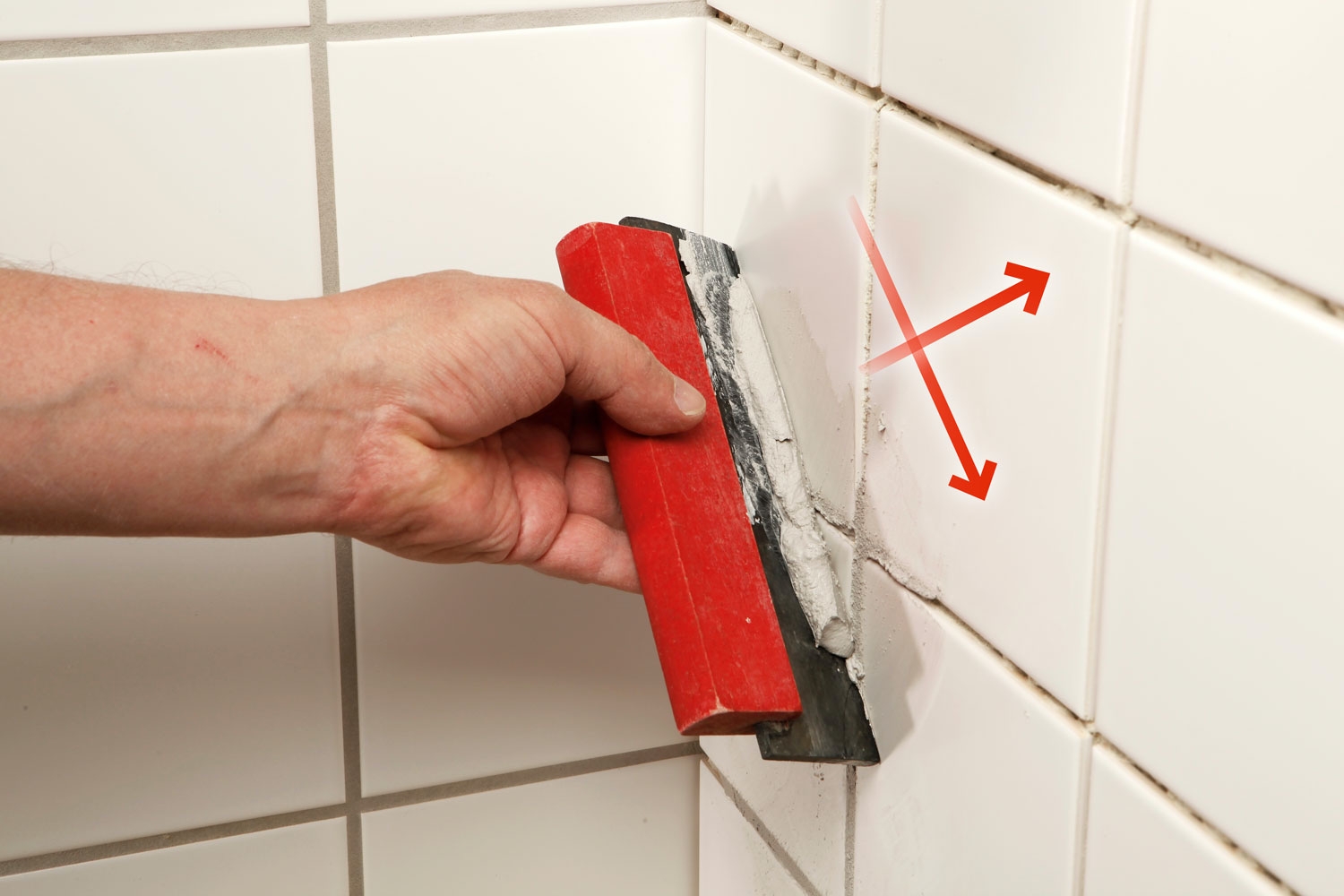 Foga kakel: Spackeln dras diagonalt över fogarna.