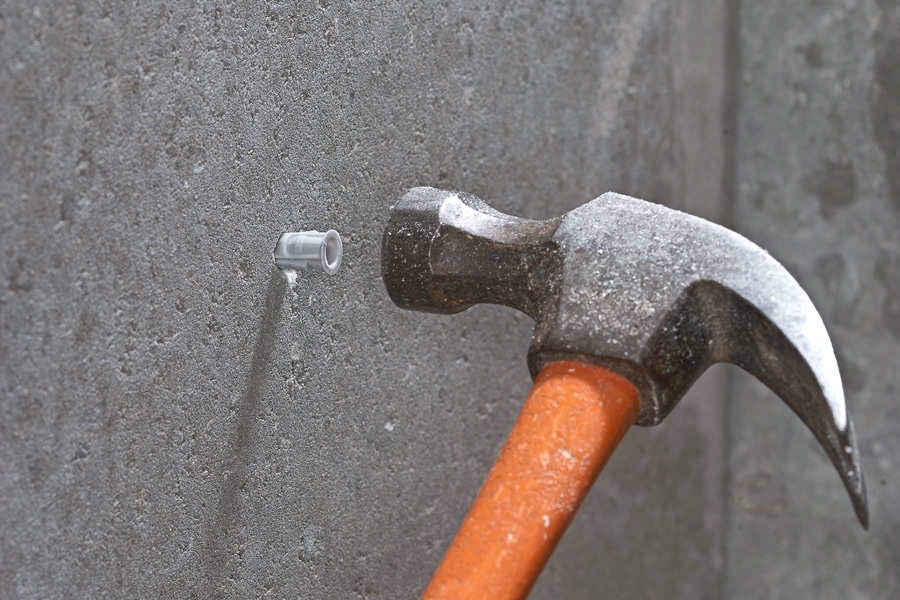 Her slås en plugg av nylon i veggen. Den ekspanderer bedre enn plugger av plast.