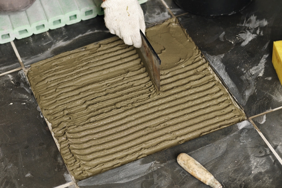 Asenna uusi laatta: Sekoita laasti ohjeiden mukaan ja levitä sitä koloon laastikauhalla.