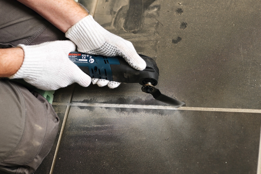 Irrota särkynyt laatta: Särkynyt laatta pitää irrottaa viereisistä laatoista ennen poistamista.