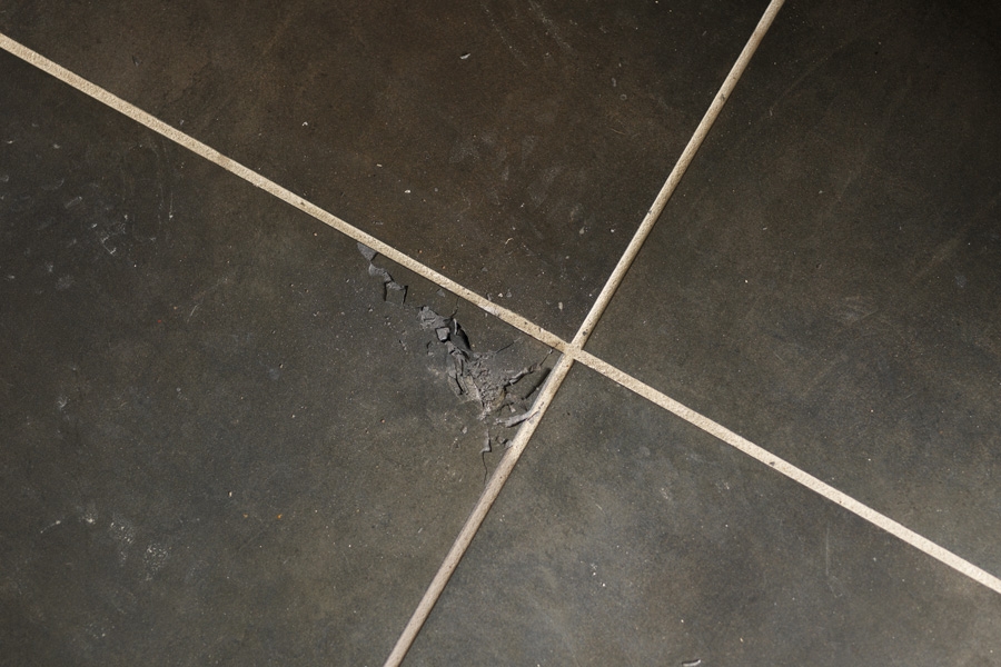 Det gælder om at fjerne den ødelagte flise i mindre stykker, så man ikke risikerer at slå skaller af fliserne ved siden af.