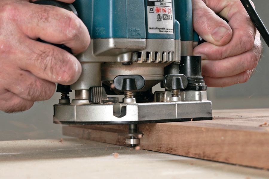 Mål op, og fræs en not: Når fræsedybden er indstillet og låst, kan overfræseren startes.