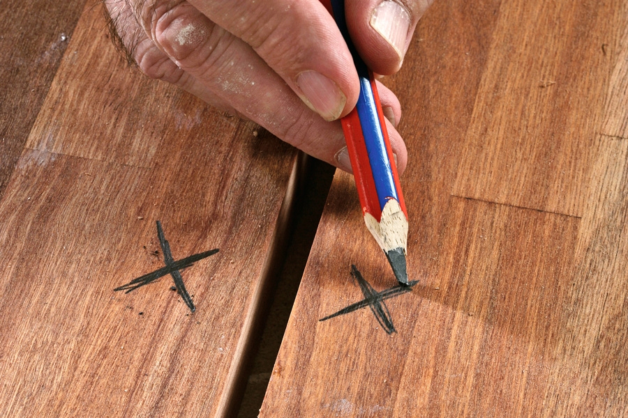 Mål op, og fræs en not: Sæt et kryds på oversiden af begge de plader, der skal samles.