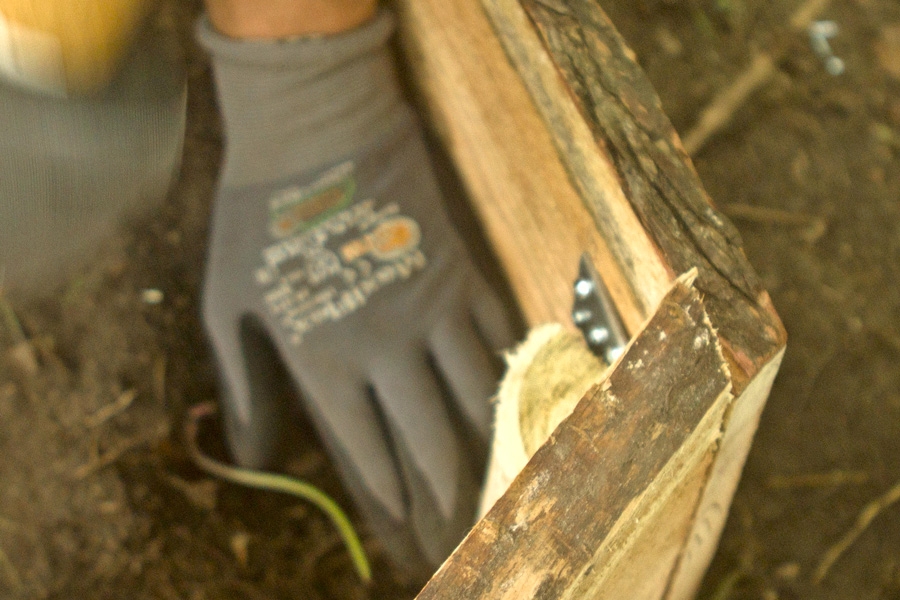 Upota tolpat joka nurkkaan 5–10 senttiä nuotiopaikan pinnan alapuolelle. Ruuvaa tolpat kiinni lautoihin 5x70 millin ruuveilla ja täytä kuopat maalla.
