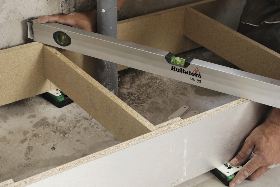 Sokkel til kjøkken: Sokkelstykkene settes sammen, og sokkelen legges ned på gulvet så du kan få den i vater