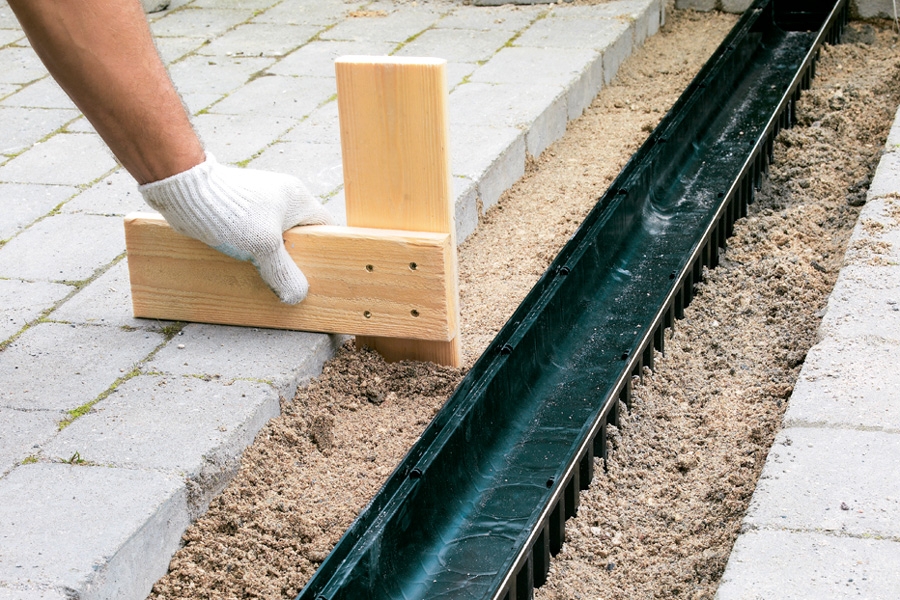 Fyld op med afretningsgrus rundt om renden, når betonen er blevet hård. Ret gruslaget af, så det passer med, at stenene rager 3-4 mm op, når de lægges.