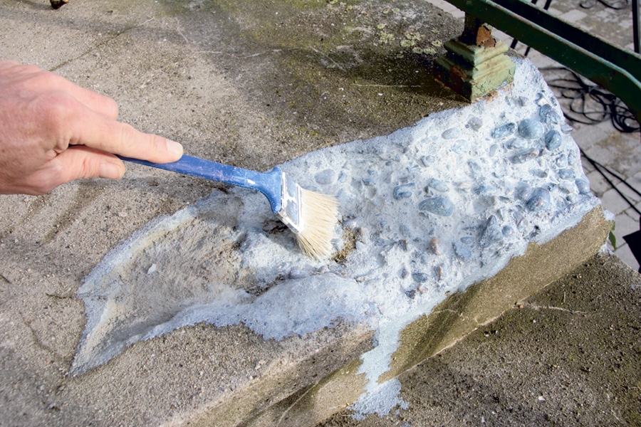 Med en pensel smører vi forankringsgrunder (primer) på betontrappen.