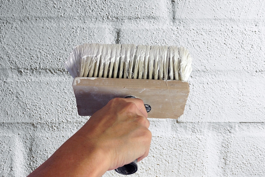 Mal facaden: Dyp ca. halvdelen af kosten i pudsen, og mal den på.