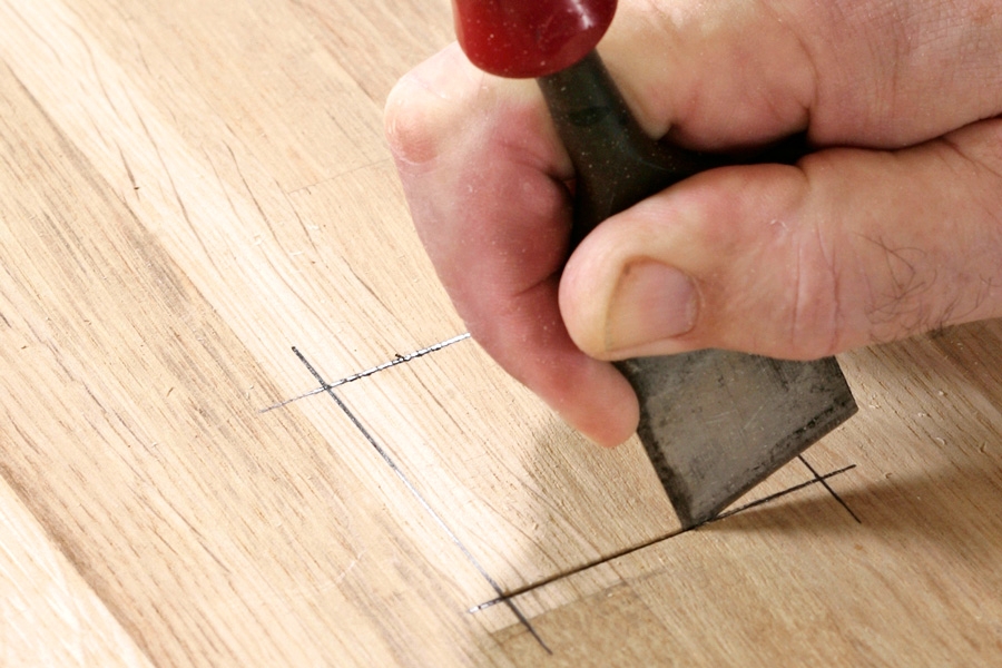 Stemjern: Strek opp tapphullet (her 5 x 5 cm) med en blyant, og riss opp strekene med hjørnet av stemjernet. Det sikrer at jernet ikke sklir når tapphullet skal hugges ut etterpå.
