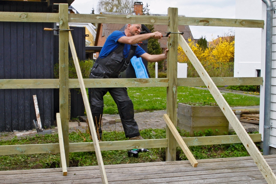 Efterhand som man reser stolparna, förses de med snedsträvor och avståndet mellan dem säkras med liggande distansbrädor.