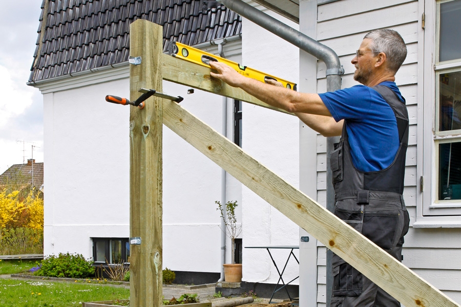 När den första stolpen står i sitt hål, stagas den upp med en snedsträva. Om den fästs med en tving, är det lätt att justera stolpen. Snedsträvan fästs i andra änden till en pinne som slås ner i marken.
