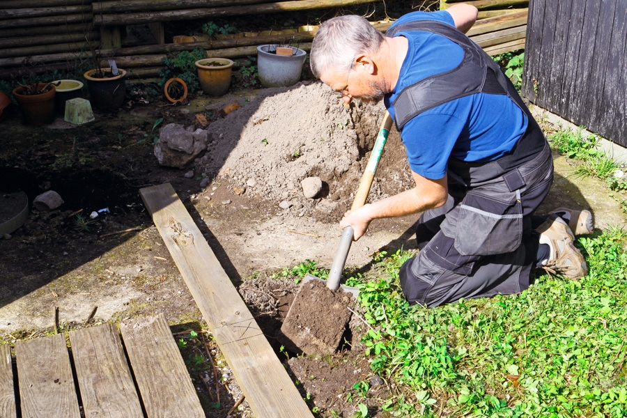 Först grävs hålen till stolparna. De ska vara ca 30 x 30 cm och minst 90 cm djupa. För att mäta ut var hålen ska grävas, kan man markera dem på en lång bräda, som man gräver efter.