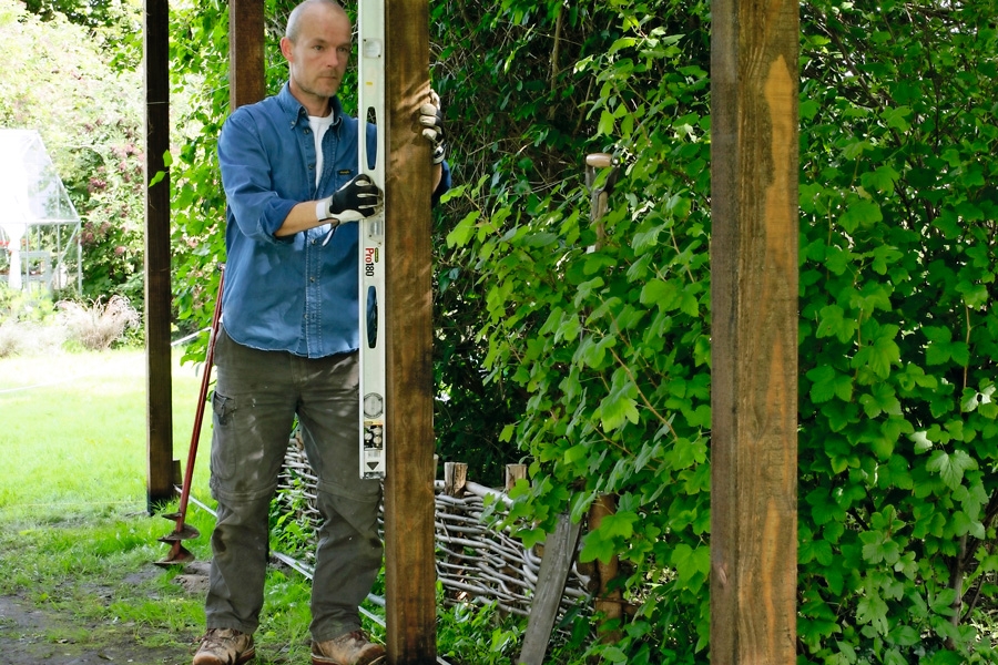 Alla stolpar rättas in med ett långt vattenpass - om man inte är så lyckligt lottad att man äger ett stolpvattenpass. Jorden packas hårt runt stolparna, när de står som de ska.