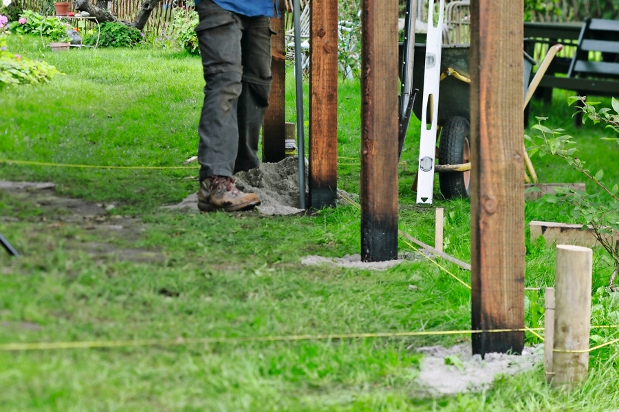 Innan resten av stolparna ställs på plats, dras snöre mellan hörnen. Dra två snören, ett lite över marken och ett högre upp - så får man koll på om stolparna lutar utåt eller inåt.