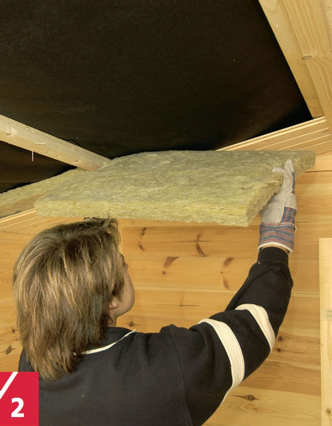 Ulkosaunan kattopaneleiden päälle työnnetään eristelevyjä