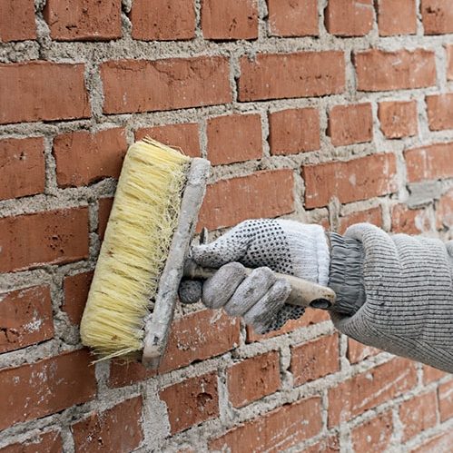 Tiiliseinän rappaus: Seinä kastellaan hyvin harjan avulla