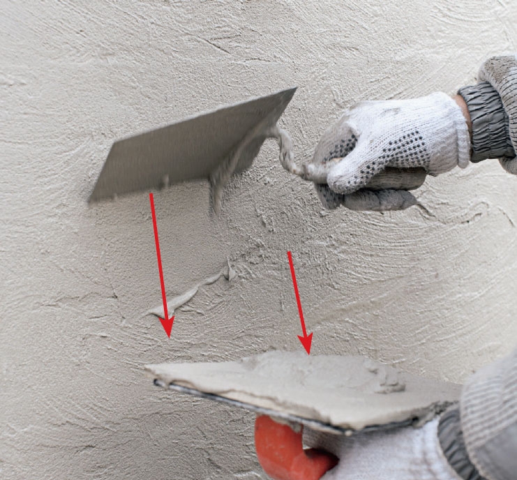 Tiiliseinän rappaus: Laastia raavitaan pois pinnasta muurauslastalla