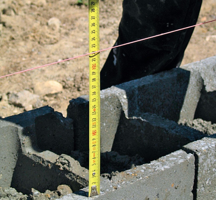 Fundament til skur: I den våde beton sættes der nu fundablokke