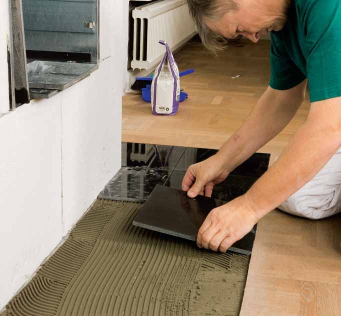 Montere peisinnsats: Flisene legges ned i limet og trykkes fast