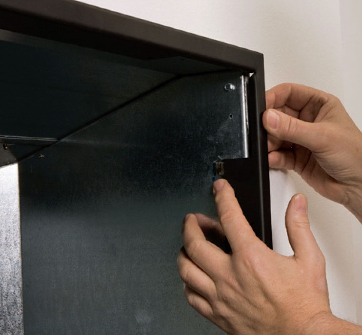 Pejseindsats: Den sorte kantafdækning trykkes i de fire clips