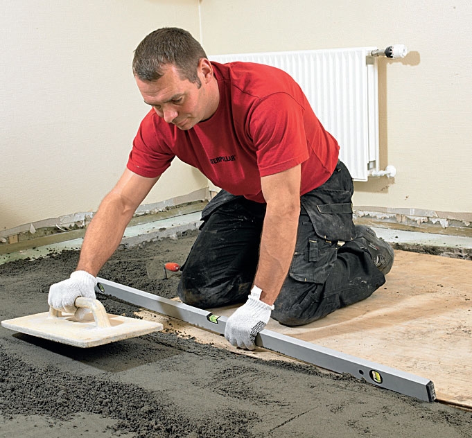 Støbning af gulv med gulvvarme: Lederen bliver glattet med et pudsebræt