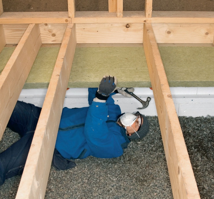 Isolering af krybekælder: Isoleringspladerne sømmer vi fast fra undersiden