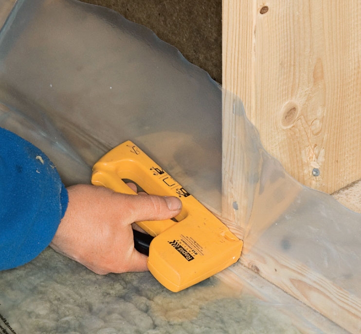 Isolera krypgrund: Längs sidorna fästs folien med häftklammer